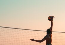 여름철 해변에서 즐기는 운동 게임 man playing beach volleyball during daytime