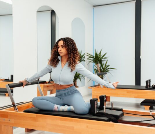 필라테스와 요가의 차이점과 선택 가이드 a woman sitting on a piyor in a room