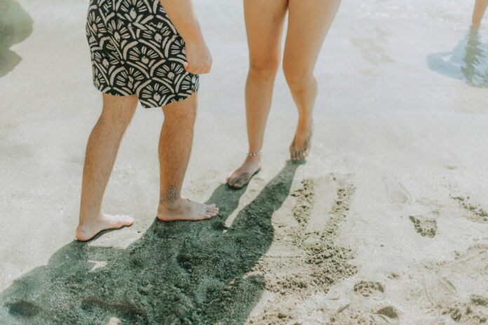 Photo by Kiril Krsteski Two people walking on a sandy beach