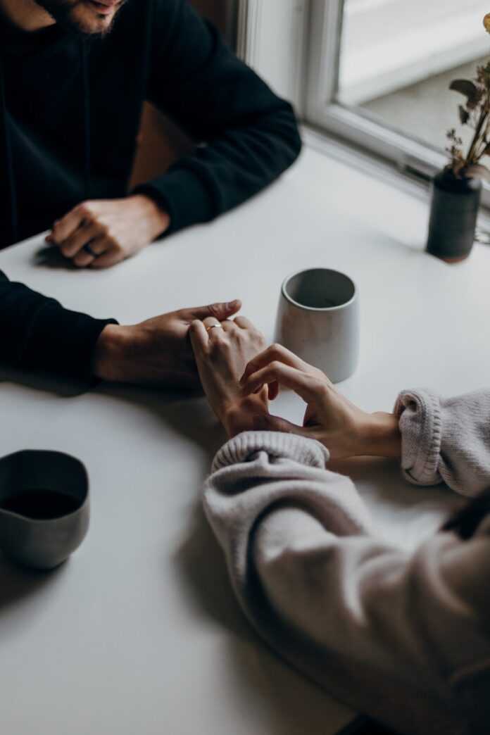 Photo by Priscilla Du Preez 🇨🇦 person in black long sleeve shirt holding white ceramic mug