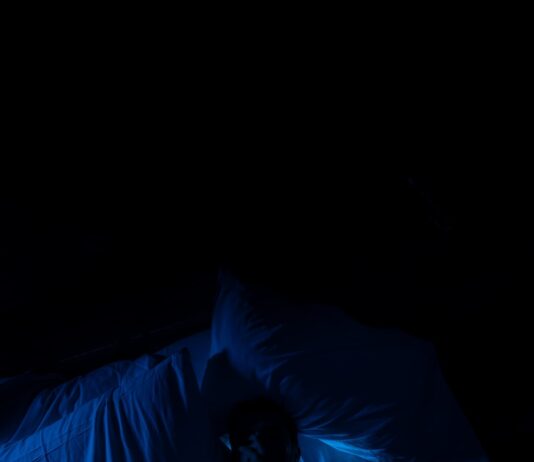 “잠이 보약”…현대인 위한 수면 혁신 트렌드와 실전 꿀팁 A person laying in a bed in a dark room