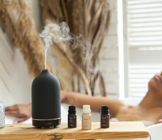 바쁜 일상 속 ‘마음 챙김’ 실천, 소소한 변화가 건강을 부른다 a woman laying in a bathtub next to a bottle of essential oils